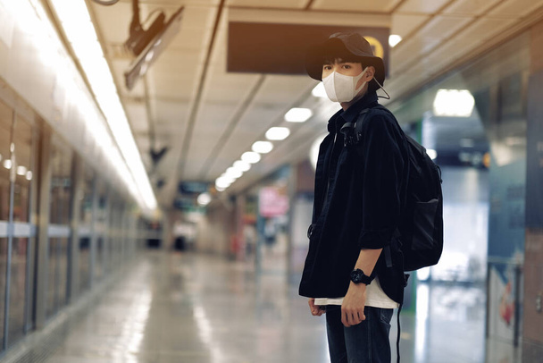Asian travelers men and camera in train station with medical face mask to protection the Covid-19, new normal lifestyle - Foto, Imagen