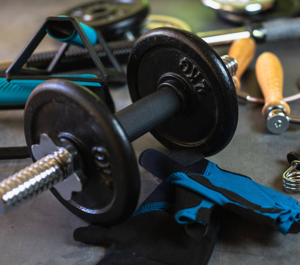 Items for training at the gym or at home. Dumbbells, Push up bars, weight plates of different sizes, jump rope, training gloves and hand grips. - Fotoğraf, Görsel