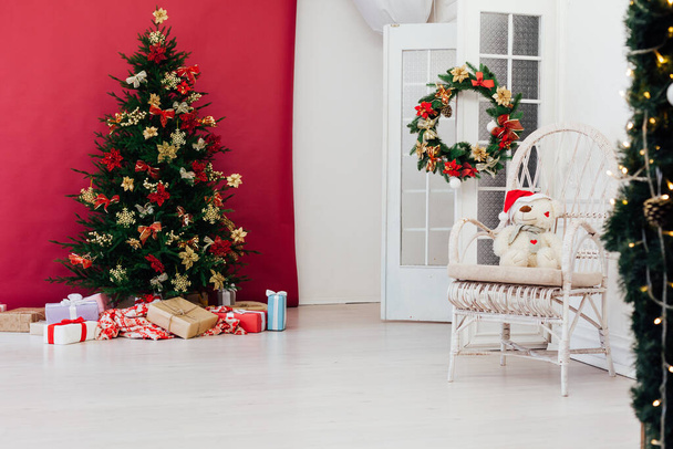 red decor garland Christmas tree with gifts for the new year - Foto, imagen