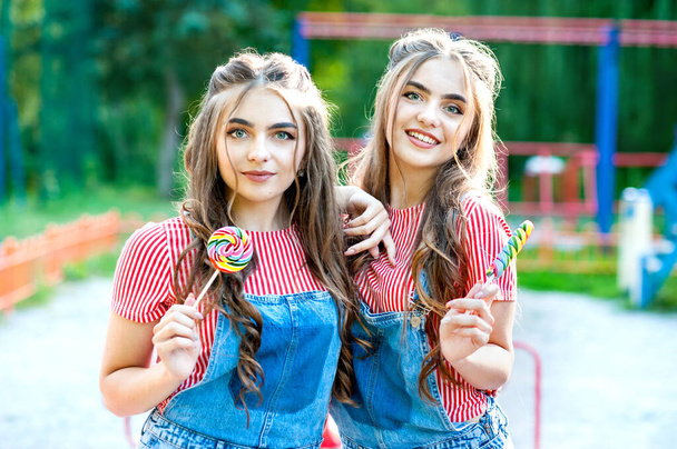 Schöne Teenager-Zwillingsschwestern mit bunten Lutschern - Foto, Bild