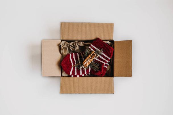 Budget christmas gifts, Cheap Christmas presents, Inexpensive Xmas. Gift Ideas for a Tight Christmas Budget. Cardboard box with packaging kraft paper and one gift - Fotografie, Obrázek