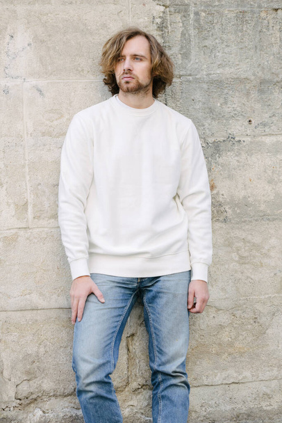 Man wearing white sweatshirt or hoodie for mock up, logo designs or design prints with with free space on the city streets. - Valokuva, kuva