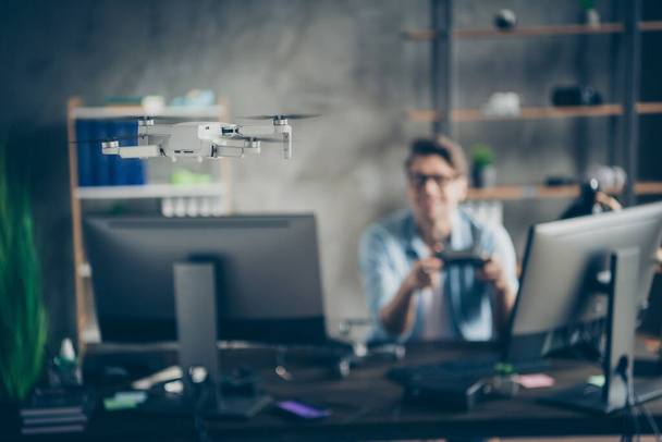 Portrait of his he nice attractive guy geek specialist expert controlling drone playing spending time testing safety at modern loft industrial home office work place station indoors - Фото, изображение