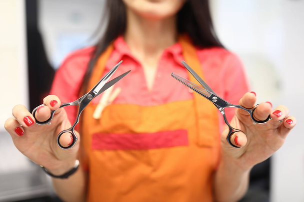 Silhouette of hairdresser woman holding scissors in foreground. - Photo, Image