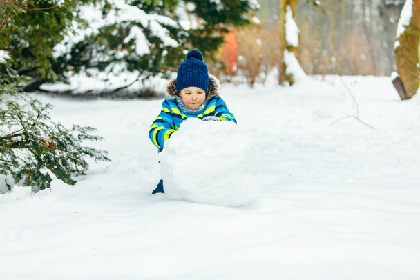 petit garçon mignon faisant bonhomme de neige. grosse boule de neige. loisirs d'hiver - Photo, image