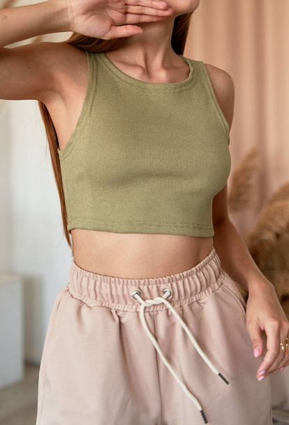 girl wears khaki color top crop. summer outfit on sporty woman model - Photo, Image
