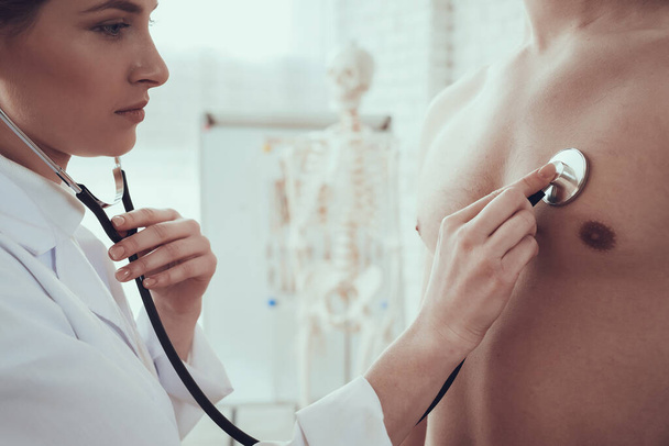 Doctor applies a stethoscope to the chest of man. - Fotó, kép