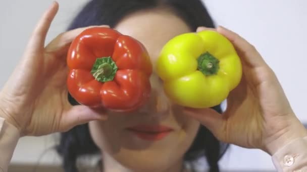 Ευτυχισμένη γυναίκα κρατώντας πιπεριές κοντά στο πρόσωπο - Πλάνα, βίντεο
