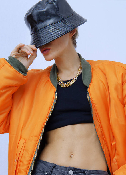 Model in fashion urban street outfit. Trendy orange bomber jacket and stylish bucket hat. Fall winter seasons lookbook. Style in details - Fotoğraf, Görsel