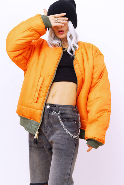 Blonde girl in fashion urban street look. Trendy orange bomber and stylish Ripped jeans. Fall winter seasons lookbook - Fotoğraf, Görsel