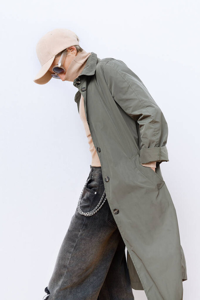 Model in fashion urban street outfit. Trendy cap and military coat. Stylish Fall winter seasons. Casual look book - Zdjęcie, obraz