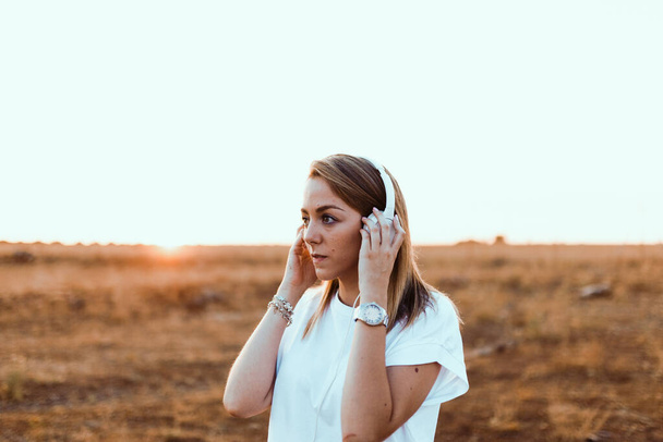 Mujer joven con su portátil escuchó comunicaciones externas con auriculares - Foto, Imagen