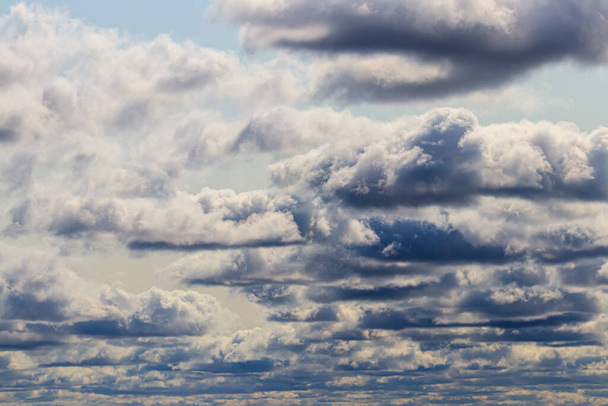 Strahlend blauer Himmel mit dramatischen Kumuluswolken, die von der Tagessonne erhellt werden. Abstrakter Hintergrund. - Foto, Bild