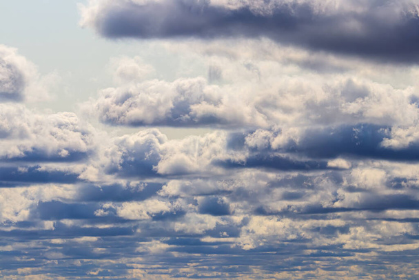 Cielo azul brillante con nubes de cúmulos dramáticas iluminadas por el sol diurno. Fondo abstracto. - Foto, Imagen