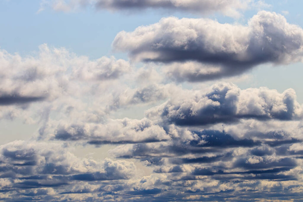 Strahlend blauer Himmel mit dramatischen Kumuluswolken, die von der Tagessonne erhellt werden. Abstrakter Hintergrund. - Foto, Bild
