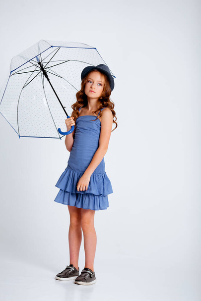 habillé d'une robe bleu clair sur bretelles spaghetti petite fille sur un fond blanc - Photo, image