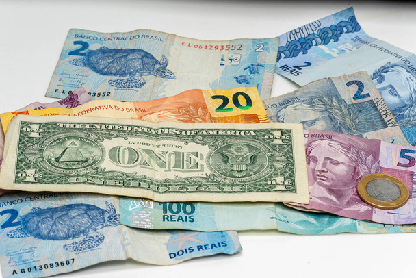 one dollar bill on Brazilian money notes, devaluation of Brazilian money - Photo, Image