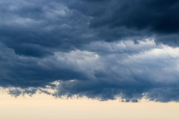 Donkerblauwe zware stormwolken voor een onweer of orkaan. Dramatische wolken bij bewolkt weer. Wolkenlandschap. - Foto, afbeelding