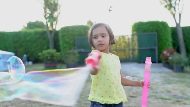 dziewczyna gra z bańki mydlane o zachodzie słońca - Materiał filmowy, wideo