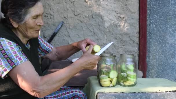 Mujer anciana cortar calabaza y poner en frasco - Metraje, vídeo