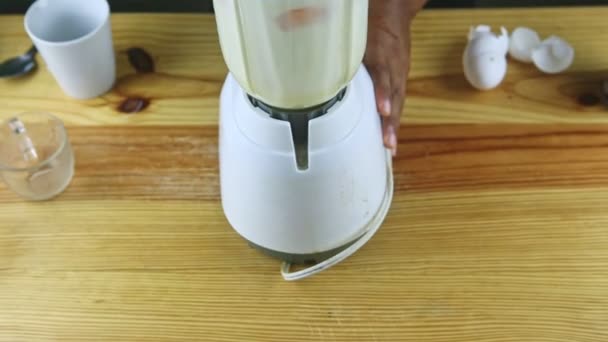 верхний вид на человека руками держит электрический блендер смешивания сгущенного молока и яиц - Кадры, видео