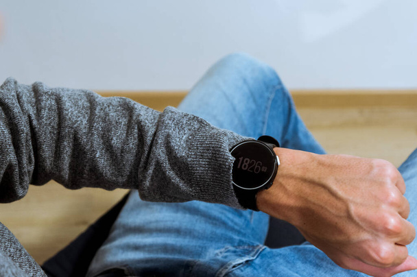 Hand dragen elegante smartwatch met klok app. over het schouderzicht. - Foto, afbeelding