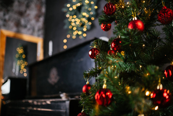 Новый 2021 год интерьер со свечами, луковицами и боке. Комнату украсили к празднованию Рождества. Рождественская елка с подарками - Фото, изображение