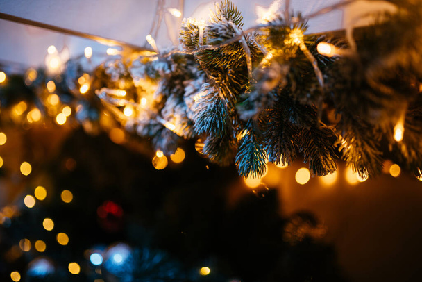 New Year 2021 interior with candles, bulbs and bokeh. Room decorated to christmas celebration. Christmas tree with presents - 写真・画像