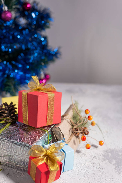 Boże Narodzenie tło prezenty na tle choinki z dekoracyjnych zabawek. Prezenty świąteczne z błyszczącym tle - Zdjęcie, obraz