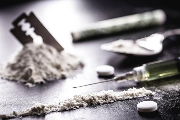 cocaína com fileiras, fileiras e linhas de pó a serem testadas, com uma lâmina de baba ao lado e seringas - Foto, Imagem
