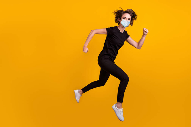 Full length body photo of girl jumping running shopping center use medical mask isolated yellow color background - Fotó, kép