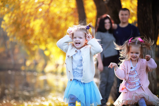 Caduta di foglie nel parco. Bambini per una passeggiata nel parco autunnale. Famiglia. Caduta. Felicità. - Foto, immagini
