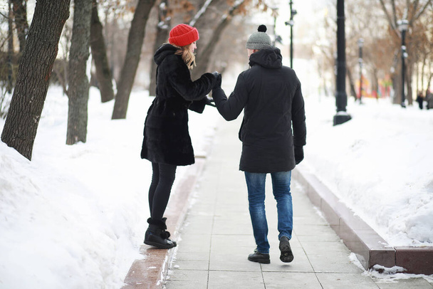 Νεαρό ζευγάρι περπατά μέσα στη χειμερινή πόλη - Φωτογραφία, εικόνα