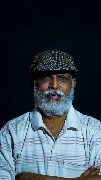 A vertical shot of an Asian middle-aged man with a beard hat and a serious face - Foto, Imagen