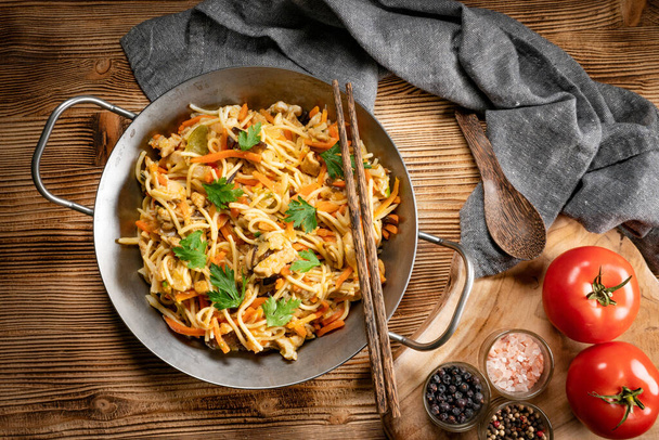 Fried noodles with chicken and vegetables. Chicken chow mein. - 写真・画像
