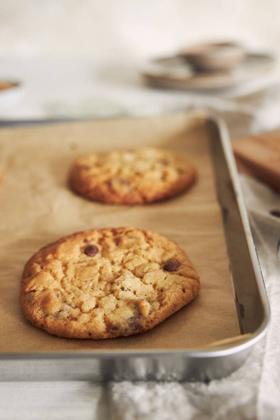 A vertical closeup of delicious chocolate chips cookies on an oven tray - Photo, Image