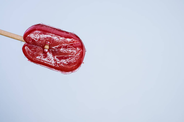 A closeup shot of red flavored lollipop isolated on white background - Photo, image