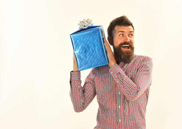 Surprise and holiday gift concept. Macho with wrapped blue gift - Photo, image
