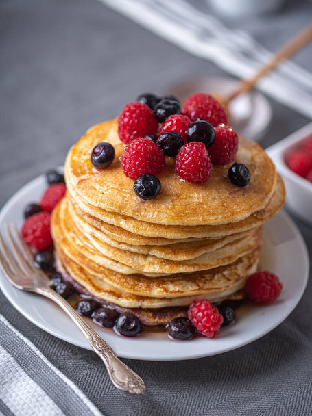 Sweet homemade pancakes with raspberries and blueberries on white plate. - Fotoğraf, Görsel