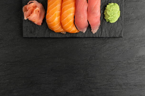 Salmon nigiri sushi and maguro tuna susi set mockup. Susi set rolls with raw red fish on dark stone plate with copy space - Zdjęcie, obraz