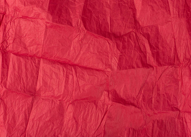Skládaný zmačkaný papír textury pozadí. Červený svraštělý svinutý cigaretový papír. Tenký balicí papír, nařezaná karmínová stránka - Fotografie, Obrázek