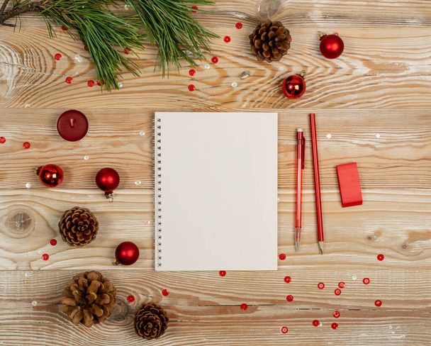 Vánoční dekorace Mockup s White Notepad Top View. Prázdný list s červenou tužkou pro seznam přání nebo vánoční přání s kopírovacím mezerou - Fotografie, Obrázek