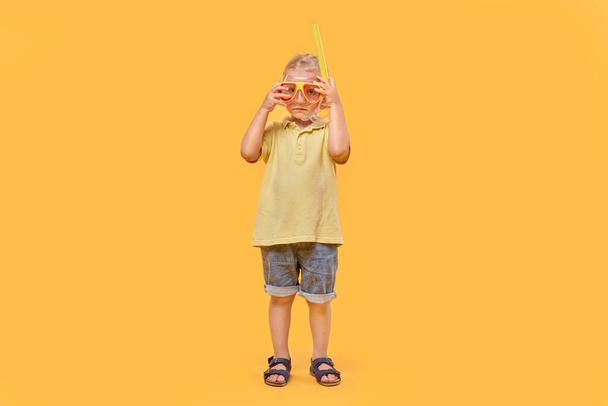 A school-age boy wearing a mask and snorkel. A boy with blond hair. - 写真・画像
