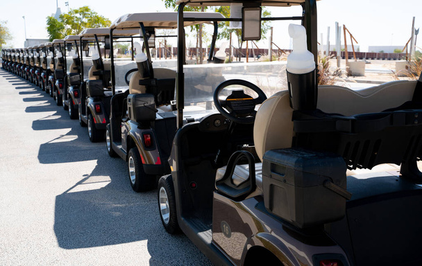 Imagen de fondo de múltiples carros de golf estacionados en orden. - Foto, imagen