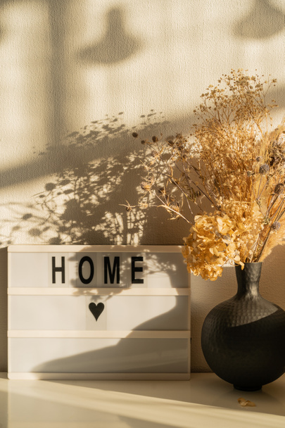 Interior del hogar. Un jarrón de flores secas en una cómoda.  - Foto, imagen