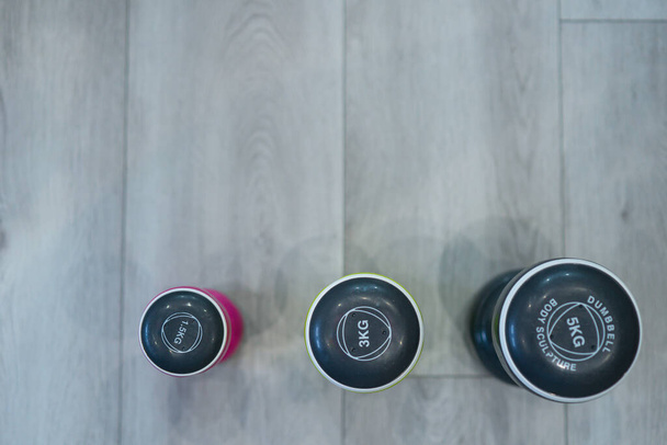 Three dumbbells on the floor in a room - 写真・画像