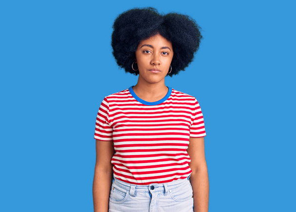 Fiatal afro-amerikai lány alkalmi ruhában, komoly arckifejezéssel. egyszerű és természetes nézi a kamerát.  - Fotó, kép