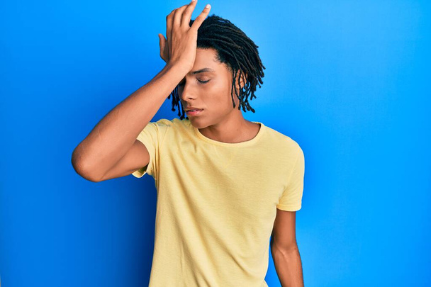 Young african american man wearing casual clothes surprised with hand on head for mistake, remember error. forgot, bad memory concept.  - Foto, Imagem