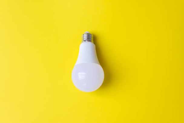 Λαμπτήρας LED σε κίτρινο φόντο. Νέα τεχνολογία της ενέργειας, έννοια της οικολογικής ισχύος. Αντιγραφή χώρου. Έννοια εξοικονόμησης ενέργειας - Φωτογραφία, εικόνα