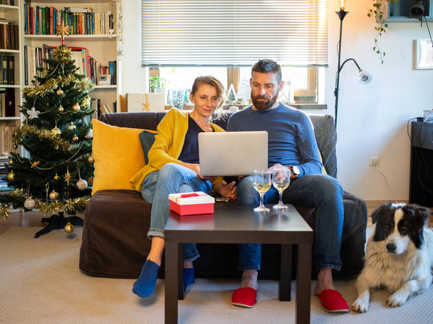 ζευγάρι γιορτάζει τα Χριστούγεννα στο σπίτι κοινωνική απόσταση - Φωτογραφία, εικόνα
